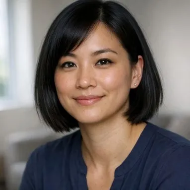 Woman in her early 30s, straight black bob, calm expression, navy blouse